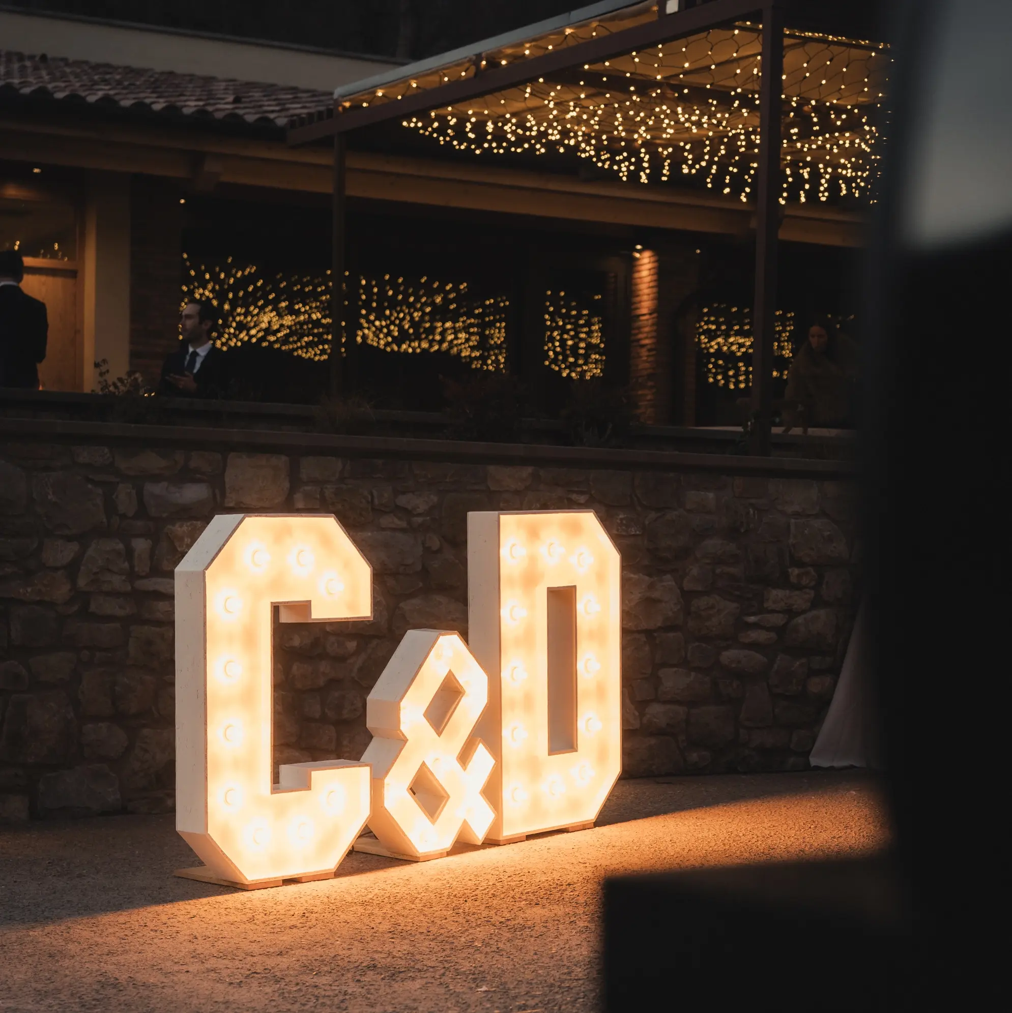 Lletres lluminoses "C&D" per a una boda nocturna a l'exterior de la masia rural Mas Pairó a Camprodon